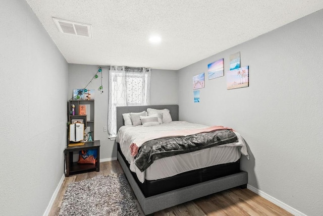 647 W Main Ave, Robstown, TX 78380 - bedroom featuring wood finished floors and a textured ceiling