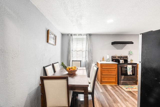 647 W Main Ave, Robstown, TX 78380 - dining area featuring wood finished floors, a textured ceiling, and a textured wall