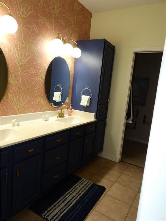 bathroom featuring double vanity, wallpapered walls, tile patterned flooring, and a sink