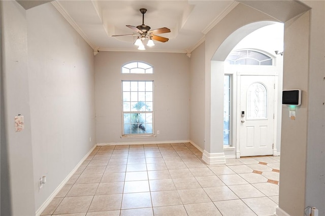 living area with light tile patterned floors, a tray ceiling, arched walkways, and a ceiling fan