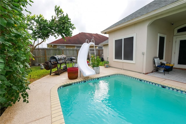 view of swimming pool featuring a patio and a water slide