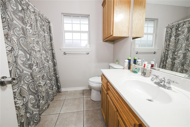 bathroom with toilet, vanity, and tile patterned floors