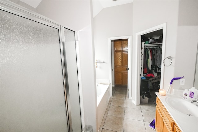 bathroom featuring independent shower and bath, vanity, vaulted ceiling, and tile patterned flooring