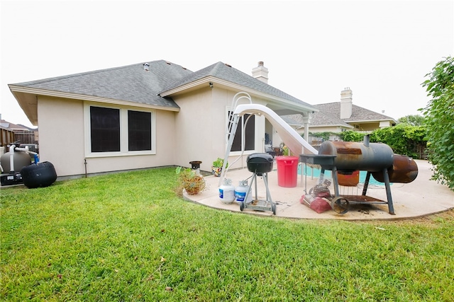 rear view of house with a lawn and a patio