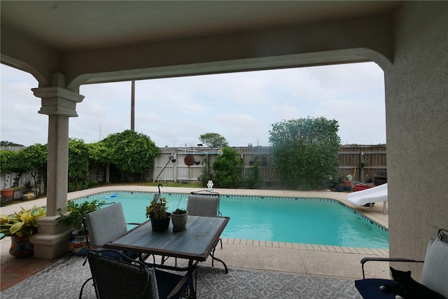 view of swimming pool with a water slide and a patio area