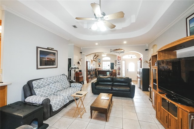 living room with ornamental molding, light tile patterned flooring, ceiling fan, and a raised ceiling