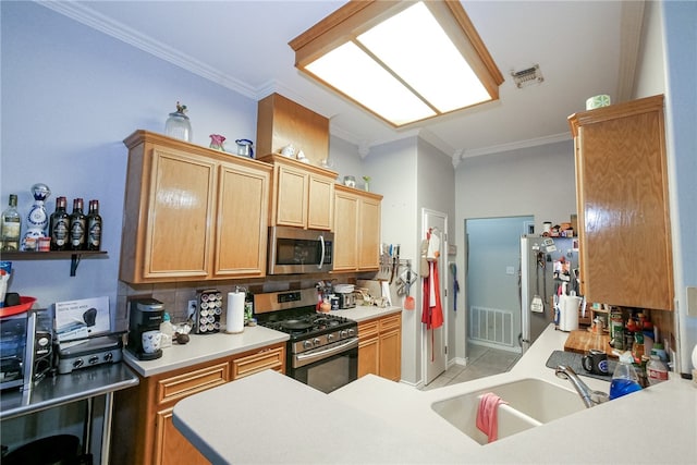 kitchen with ornamental molding, stainless steel appliances, sink, and tile patterned floors