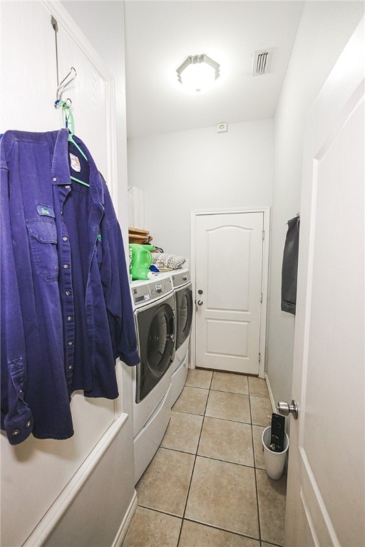 laundry area featuring washing machine and clothes dryer and light tile patterned floors