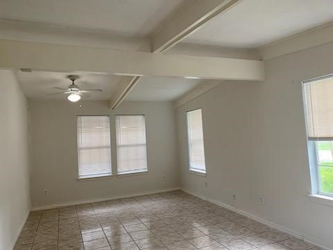 spare room featuring ceiling fan, beam ceiling, and baseboards