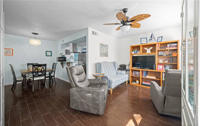 living room with ceiling fan and dark hardwood / wood-style flooring