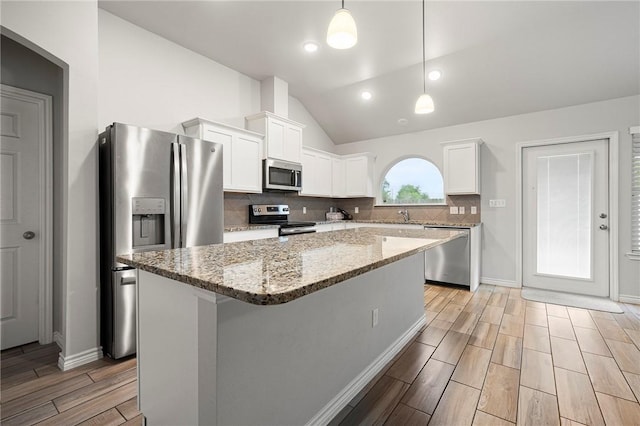 10113 Maverick, Corpus Christi, TX 78410 - kitchen featuring stainless steel appliances, wood finish floors, vaulted ceiling, white cabinetry, and decorative backsplash