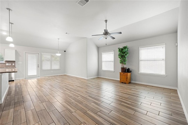 10113 Maverick, Corpus Christi, TX 78410 - unfurnished living room with visible vents, vaulted ceiling, ceiling fan, baseboards, and light wood-style floors