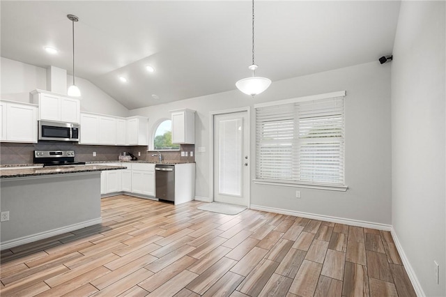 10113 Maverick, Corpus Christi, TX 78410 - kitchen featuring light wood finished floors, stainless steel appliances, white cabinets, vaulted ceiling, and tasteful backsplash