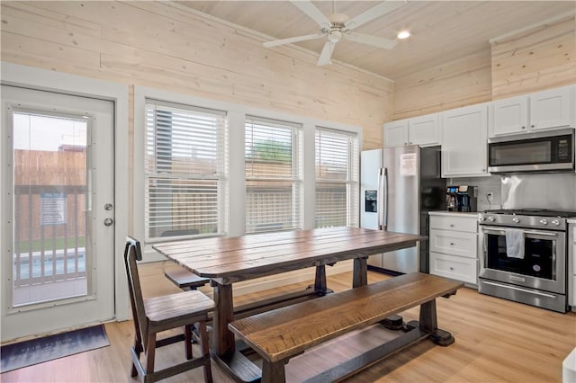 kitchen with light wood-type flooring, wooden ceiling, ceiling fan, stainless steel appliances, and white cabinets