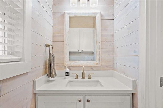 bathroom featuring vanity and wood walls