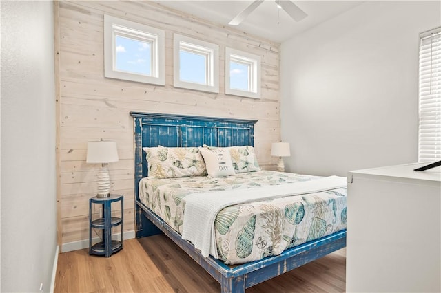 bedroom with multiple windows, hardwood / wood-style floors, and ceiling fan