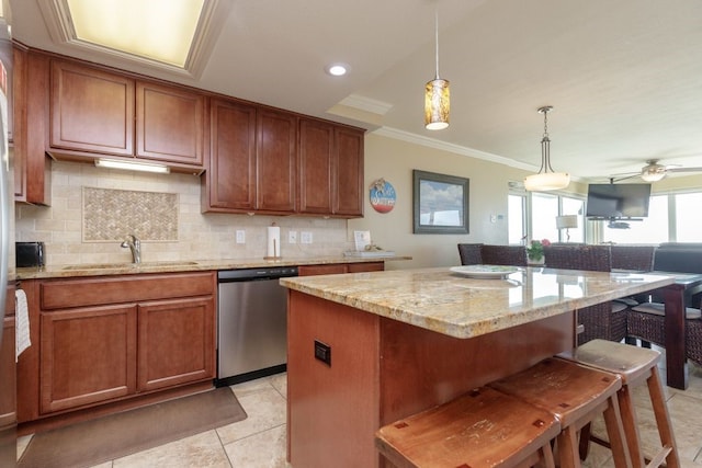 kitchen with light stone counters, a kitchen bar, sink, dishwasher, and a center island