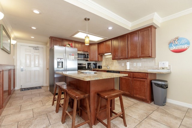 kitchen featuring a kitchen bar, decorative backsplash, crown molding, appliances with stainless steel finishes, and decorative light fixtures