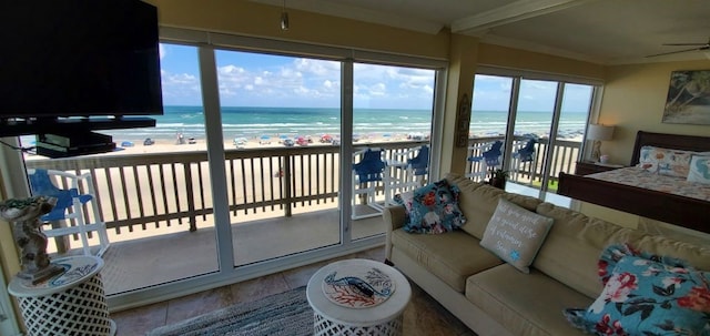 sunroom / solarium with a beach view, a water view, and ceiling fan