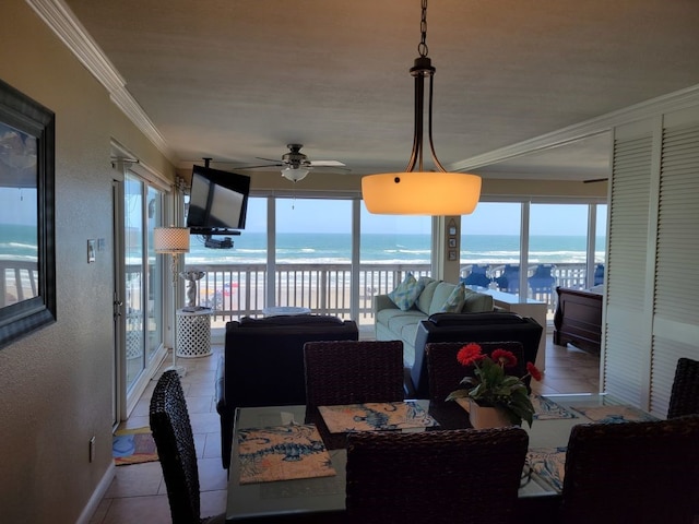 tiled dining space with ceiling fan, ornamental molding, and plenty of natural light