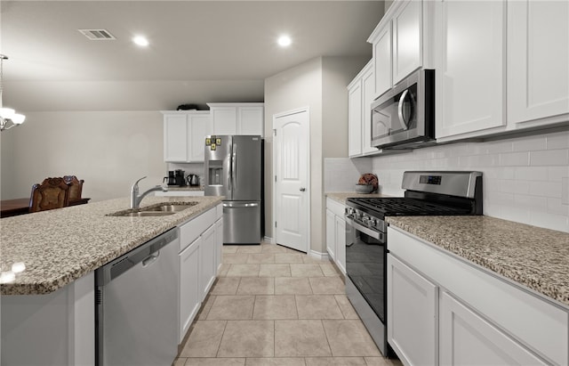 kitchen with sink, white cabinets, hanging light fixtures, and stainless steel appliances