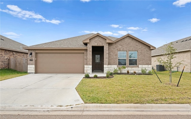 view of front of home with a garage, a front lawn, and central AC unit