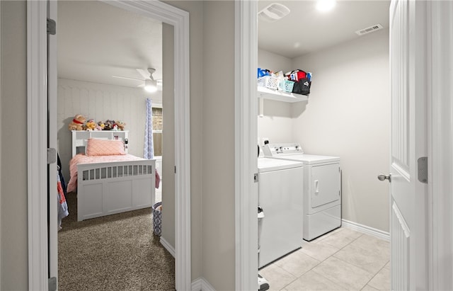 clothes washing area with ceiling fan, light colored carpet, and washer and dryer