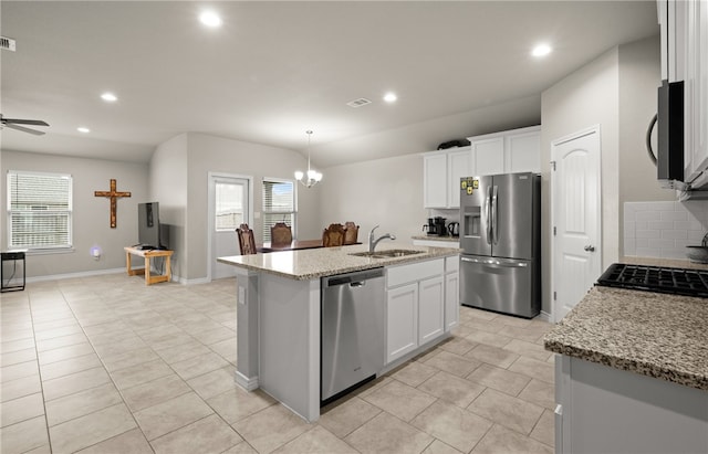 kitchen featuring sink, white cabinets, stainless steel appliances, and an island with sink