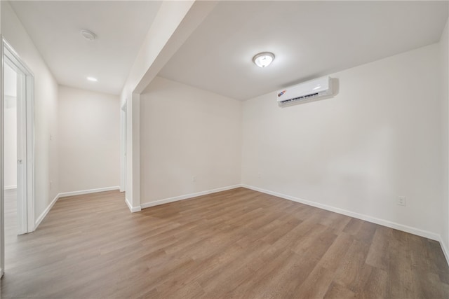 interior space with a wall unit AC and light hardwood / wood-style floors