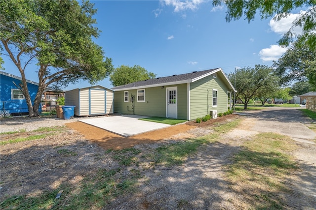 rear view of house featuring a patio area and a storage shed