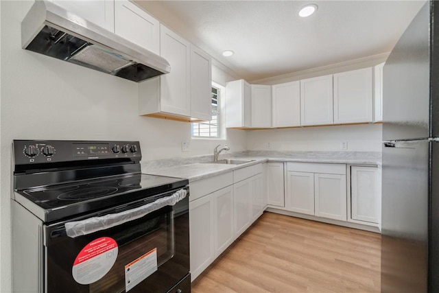 5506 Curtis Clark Dr, Corpus Christi, TX 78411 - kitchen with black electric range oven, freestanding refrigerator, wall chimney range hood, light countertops, and white cabinets