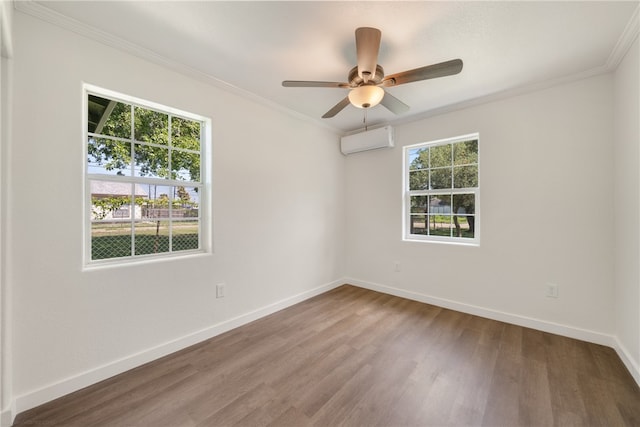 spare room with a wealth of natural light, a wall unit AC, hardwood / wood-style flooring, and ceiling fan