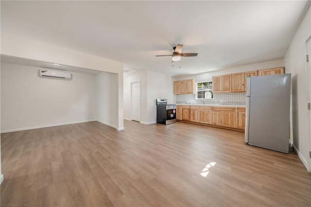 5506 Curtis Clark Dr, Corpus Christi, TX 78411 - kitchen featuring freestanding refrigerator, stainless steel range with electric cooktop, light brown cabinetry, an AC wall unit, and a ceiling fan