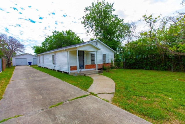 view of front of house featuring a garage, a front yard, and an outbuilding