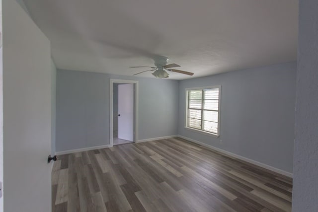 unfurnished room with dark wood-type flooring and ceiling fan