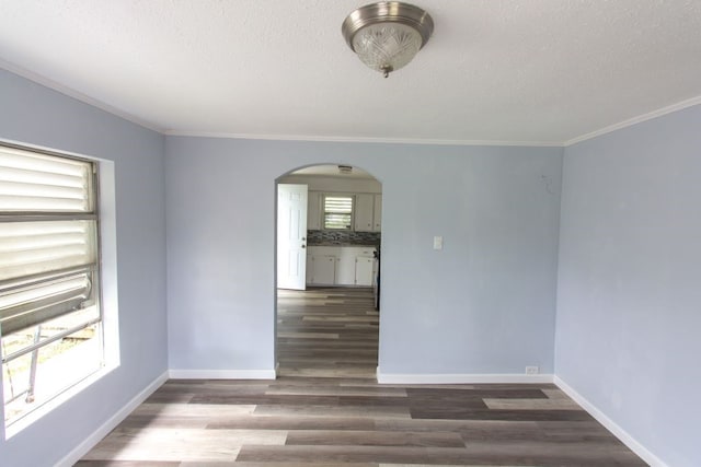 spare room featuring hardwood / wood-style flooring, a textured ceiling, and crown molding