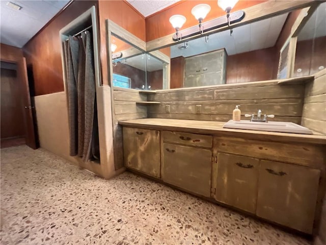 bathroom with vanity and wood walls