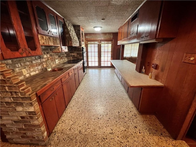 kitchen with multiple ovens, black electric stovetop, and sink