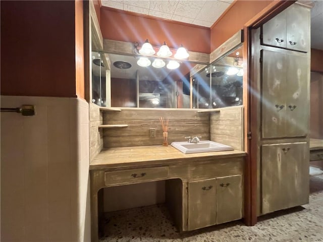 bathroom featuring vanity and tile walls