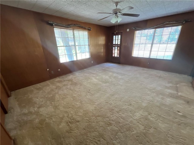 carpeted spare room with ceiling fan