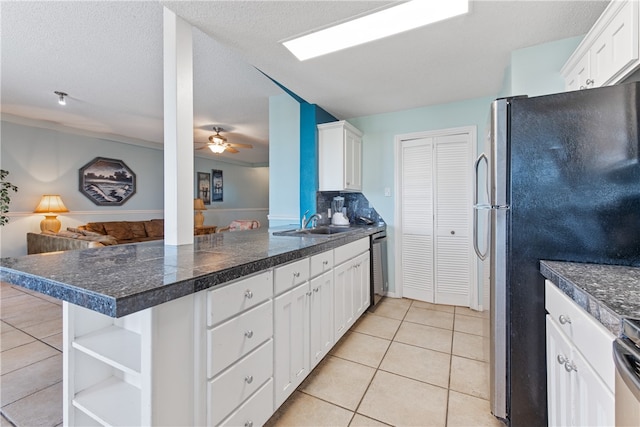 kitchen with kitchen peninsula, stainless steel appliances, light tile patterned floors, and white cabinets