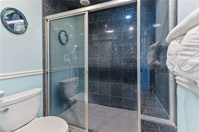 bathroom featuring toilet and an enclosed shower