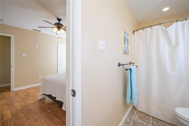 bathroom with hardwood / wood-style floors, ceiling fan, and toilet