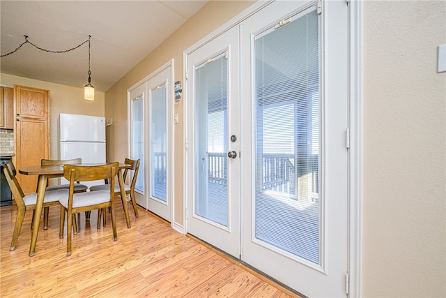 dining room with light hardwood / wood-style floors and french doors