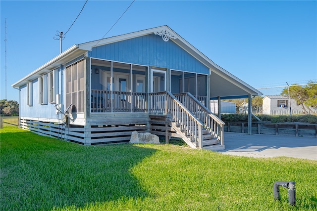 view of front of house featuring a sunroom and a front yard