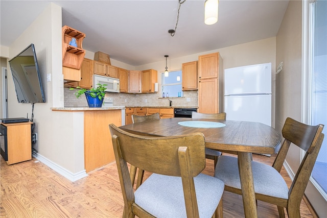 dining room featuring sink and light hardwood / wood-style flooring