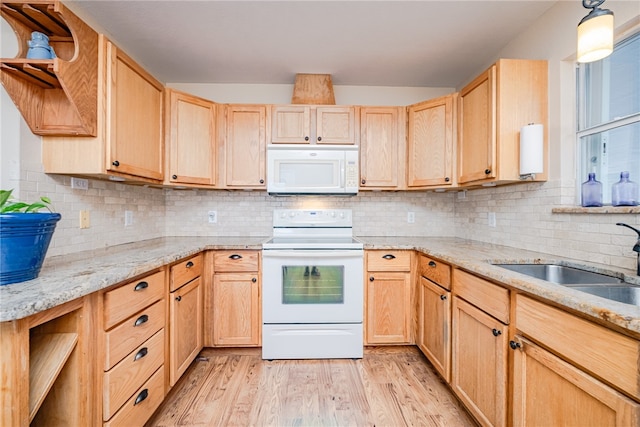 kitchen with light brown cabinetry, white appliances, light hardwood / wood-style floors, and sink