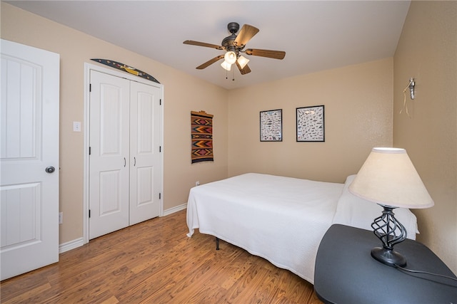 bedroom with hardwood / wood-style flooring, ceiling fan, and a closet