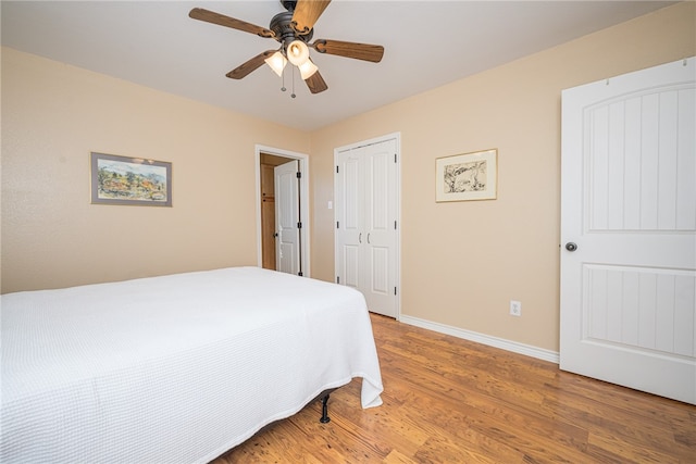 bedroom with hardwood / wood-style flooring, ceiling fan, and a closet