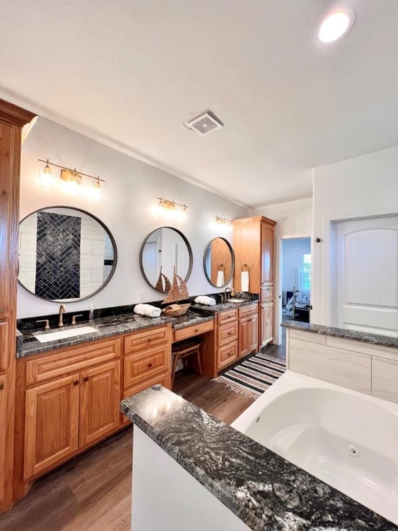 bathroom featuring a bathing tub, vanity, and hardwood / wood-style flooring